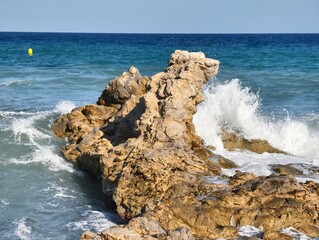 Waves crashing on the rocky shoreline create a beautiful, calming coastal experience