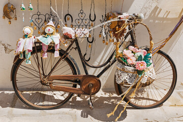 Vintage bicycle decorated with pink flowers in basket.