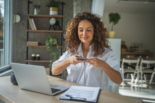 Woman scanning documents with smart phone for home office work - Powered by Adobe