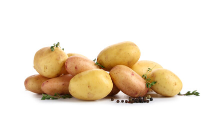 Heap of raw baby potatoes with thyme and peppercorns on white background