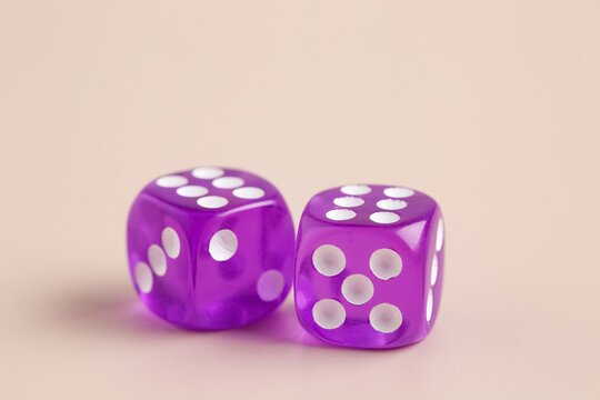 Purple game dices on beige background