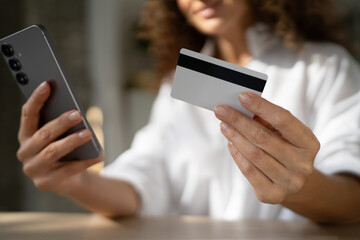 Woman holding smart phone and credit card for online payment