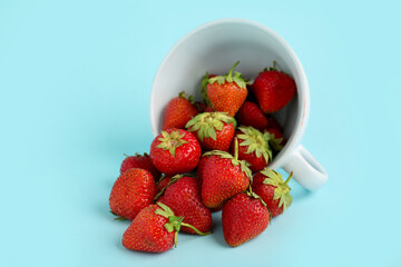 Cup with sweet strawberries on blue background