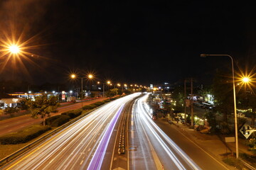 Light trails on highway at night with glowing street lights and urban atmosphere