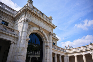 Obraz premium Elegant stone facade with arched windows and columns of a historic building in Paris, France.