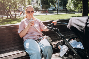 Young Mom Relaxing in Park With Child and Drink