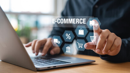 Person using a laptop with e commerce icons hovering above the keyboard and pointing with their finger
