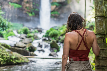 Woman in front of a waterfall in a tropical paradise