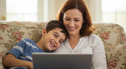 smiling mother and son enjoying time together on couch using laptop indoors