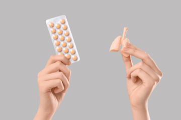Female doctor's hands with model of lungs and pills on grey background, closeup