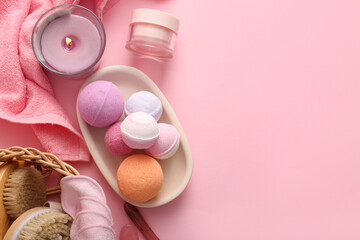 Composition with tray, burning candle and different bath bombs on pink background