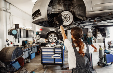 A skilled mechanic inspects a vehicle on a lift, showcasing modern automotive repair practices in a garage