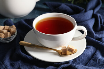 Composition with cup of black tea on blue napkin as background, closeup