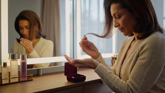 Woman applying makeup at a vanity mirror