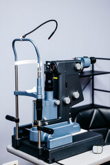 Ophthalmic equipment, a blue laser vision correction device, positioned on a table in a clinical setting, showcasing advanced technology for vision examination and treatment