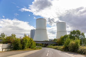 Massive cooling tower power plant Saxony  Germany releasing steam  cloudy sky. Industrial complex surrounded by fields illustrates modern energy generation, infrastructure environmental technology