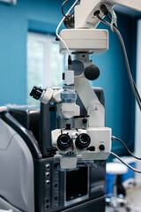 Advanced ophthalmology microscope with dual lenses and intricate components, positioned in a modern clinic, emphasizing laser vision correction technology and precision examination