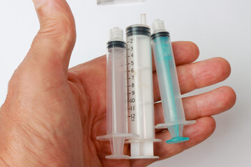 Man holding several different size Medical Syringes in his hand
