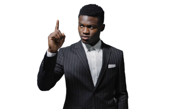 Man in a striped suit gestures confidently with one finger raised, signaling a point during a formal discussion in a bright studio setting