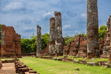 Old Buddhist temple column building ruins in a green park landscape in Ayutthaya, Thailand
