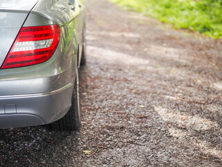 Rear of a car parked off road on rough stone surface, selective focus. Nobody. Travel and tourism.