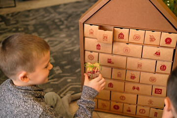 The boys open the gift boxes of the Advent calendar in anticipation of the new year.
