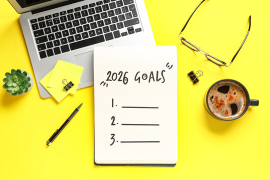 Notebook with empty to do list, laptop and cup of coffee on yellow background. New year goals