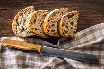 Photo of sliced ​​baked sourdough bread on wooden table. Top view.