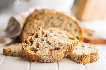 Photo of sliced ​​baked sourdough bread on white table.