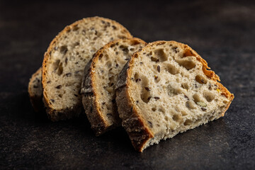 Photo of sliced ​​baked sourdough bread on black table.