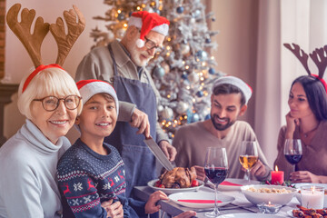 Family together at Christmas dinner at home. Happy three generation family looking at the camera...