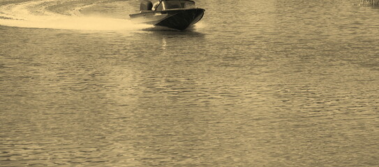 People travel along the river by boat, in summer you can see the water, the motorboat, nature, the pier