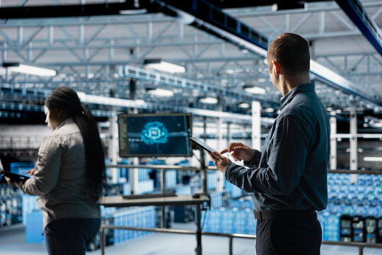 Team of data center software developers review code for AI automation scripts. Server hub coworkers run artificial intelligence assisted diagnostics on infrastructure for predictive fault detection - Powered by Adobe