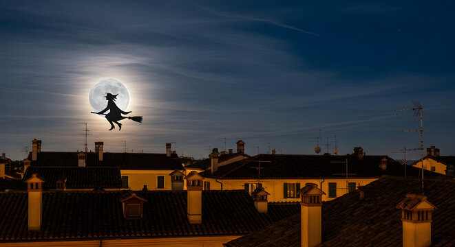 Befana witch flying over tiled rooftops of an Italian town under a glowing full moon, Epiphany folklore city scene for tourism promotions, winter festival events