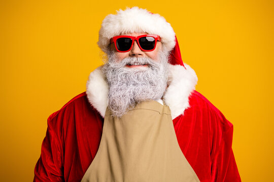 Festive portrait of a cheerful Santa Claus wearing sunglasses and a red costume on a yellow background - Powered by Adobe
