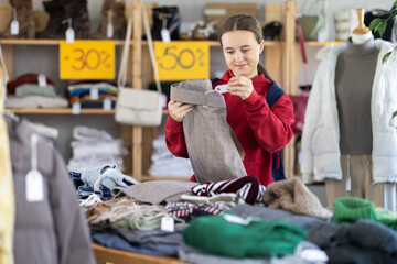 Glad teenage girl looking for pantaloons for cold season during sell-out in retail outlet