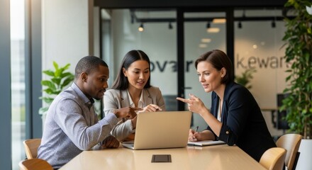 Fototapeta premium Diverse team collaborating in modern office with laptop