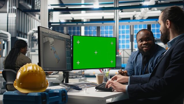 Solar panels inspection group review data on pc next to green screen, finding errors during a process audit and helping optimize renewable energy operations. Photovoltaics factory. Camera A. - Powered by Adobe
