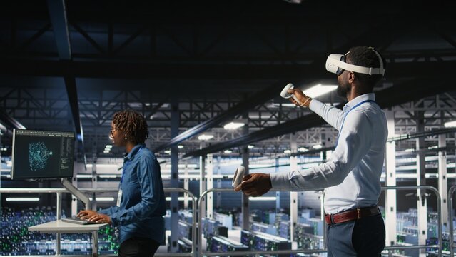 Data center admin using VR headset to monitor neural network AI systems. Server room employee using virtual reality tech to oversee equipment powering machine learning processes,