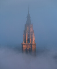Naklejka premium Toledo Cathedral tower glowing in sunrise fog, Castilla-La Mancha