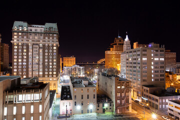 Artificial light illuminates historic skyscrapers at night in the downtown core of Memphis, Tennessee, USA.