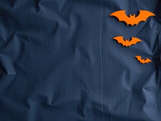 Orange bat silhouettes on navy fabric background