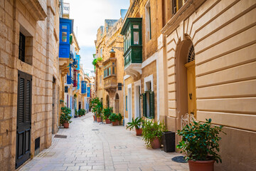 Cozy street and traditional colorful wooden balconies in Birgu, Malta © Olena Zn