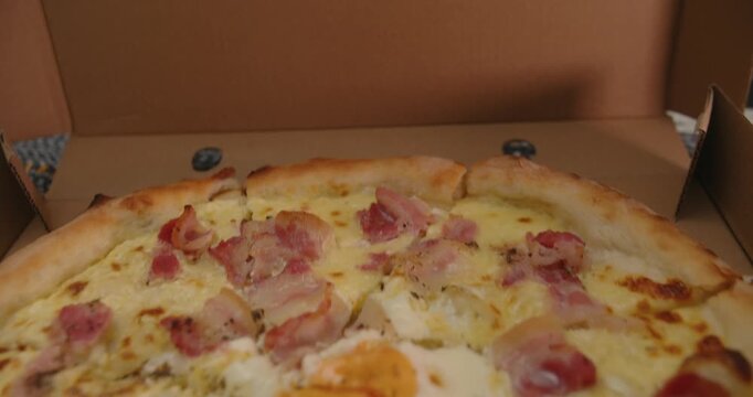 Open pizza box with delicious Italian pizza ready to serve. Perfect party food for sharing with friends and enjoying great moments together. Tasty Italian pizza in an open box.