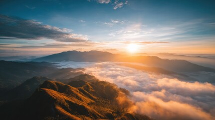 Fototapeta premium Golden rays illuminate the peaks as clouds blanket the valleys below during sunrise.
