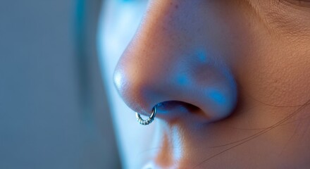 Close up of a woman with a septum piercing in her nose, showcasing body modification and personal style.