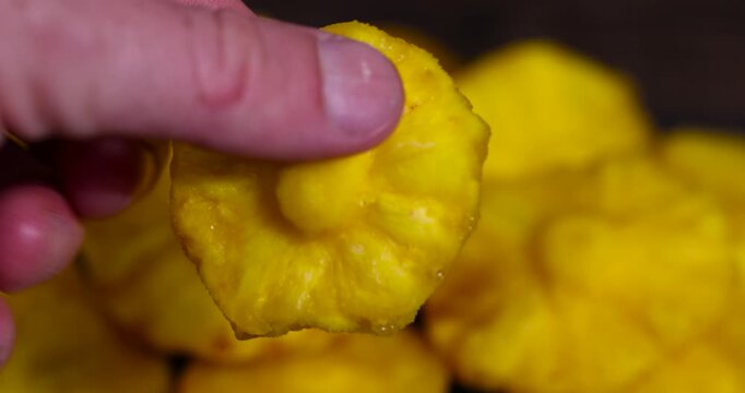 yellow pineapple fruits in a hand, cut into rings and dried yellow pineapple for long-term storage and used as a sweet