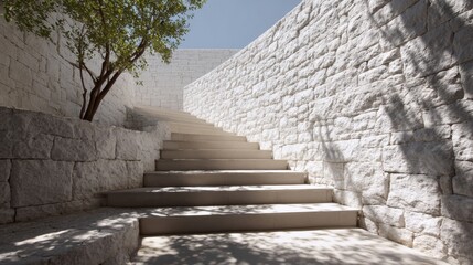 Fototapeta premium A white stone staircase leading up to a building. The steps are made of concrete and are white in color. The building is surrounded by a wall, and there is a tree in the background