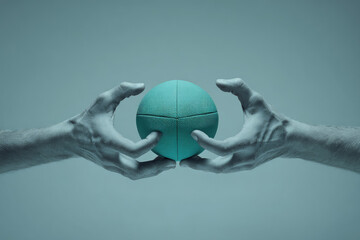 Pair of hands passing teal rugby ball minimal modern style surreal composition close up creative concept teamwork isolated monochrome blue tone