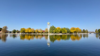 A water tower with colourful trees set against a river